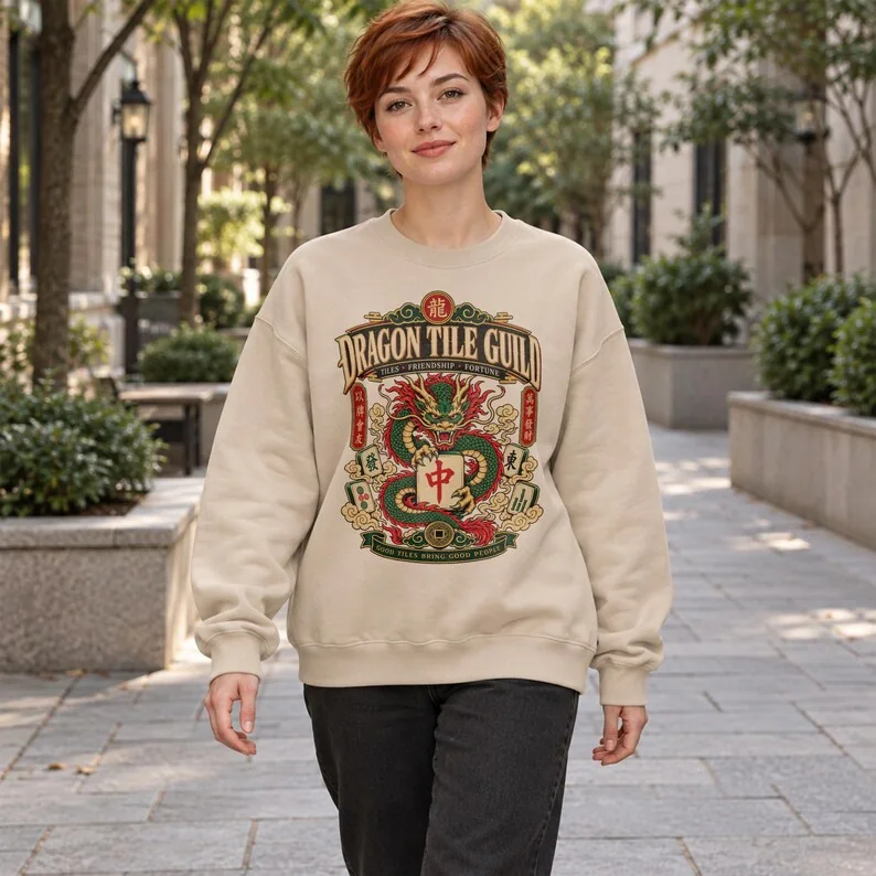 Woman wearing Sand Dragon Tile Guild sweatshirt with ornate green dragon and mahjong tile design.