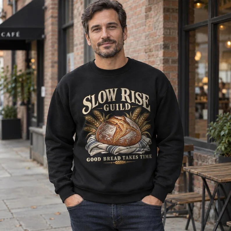 Black Slow Rise Guild sourdough sweatshirt on male model, featuring artisan bread baking graphic