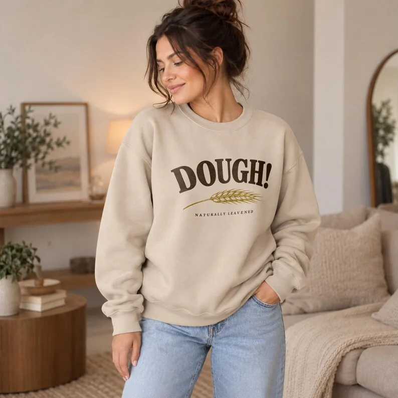 Sand DOUGH sourdough sweatshirt on woman, featuring wheat illustration and Naturally Leavened bread baker design.