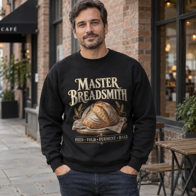Black Master Breadsmith sweatshirt on man, featuring rustic artisan bread artwork and sourdough baker typography.